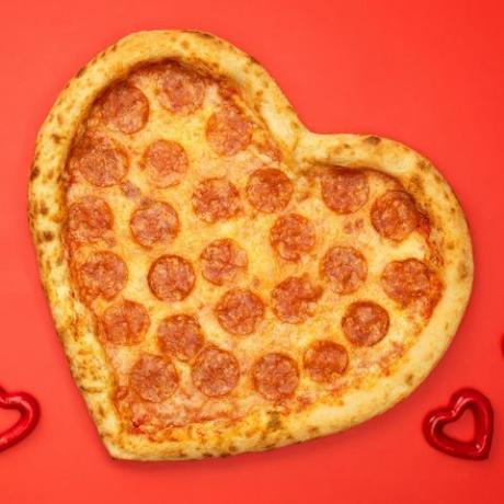 pizza pepperoni en forme de coeur pour la saint valentin sur fond de papier rouge