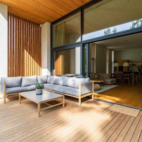 patio en bois relié à un bâtiment privé, avec coin salon et coin salon confortable, fenêtre ouverte avec entrée à la maison